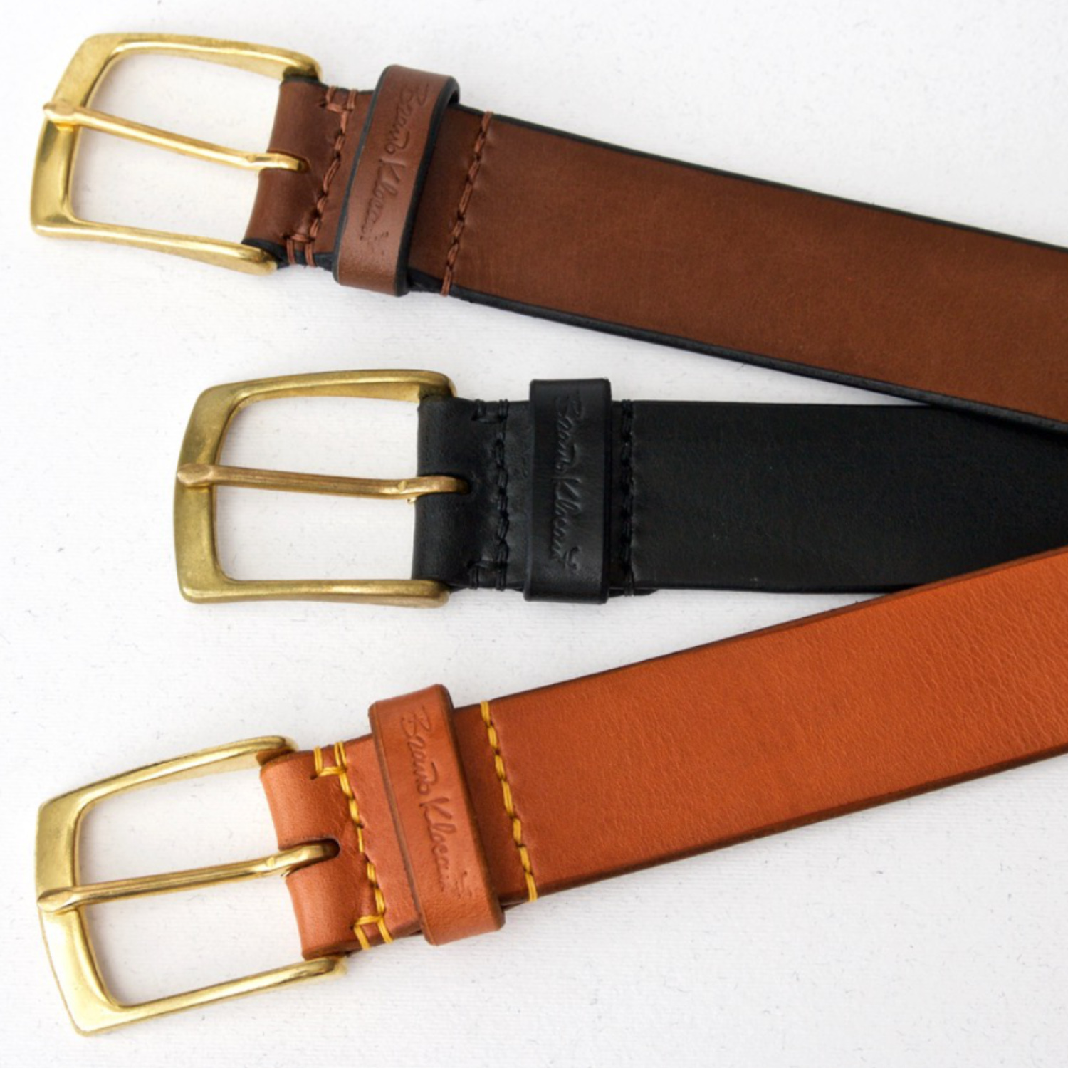 three leather belts with brass buckles
