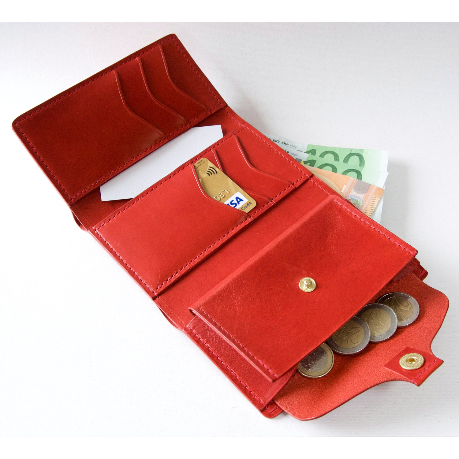 red leather trifold wallet with cards banknotes and coins inside