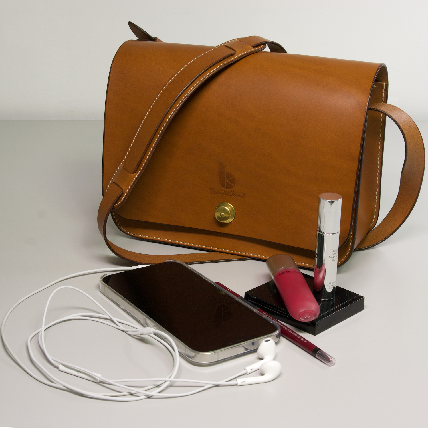 leather crossbody handbag with make up headphones and mobile