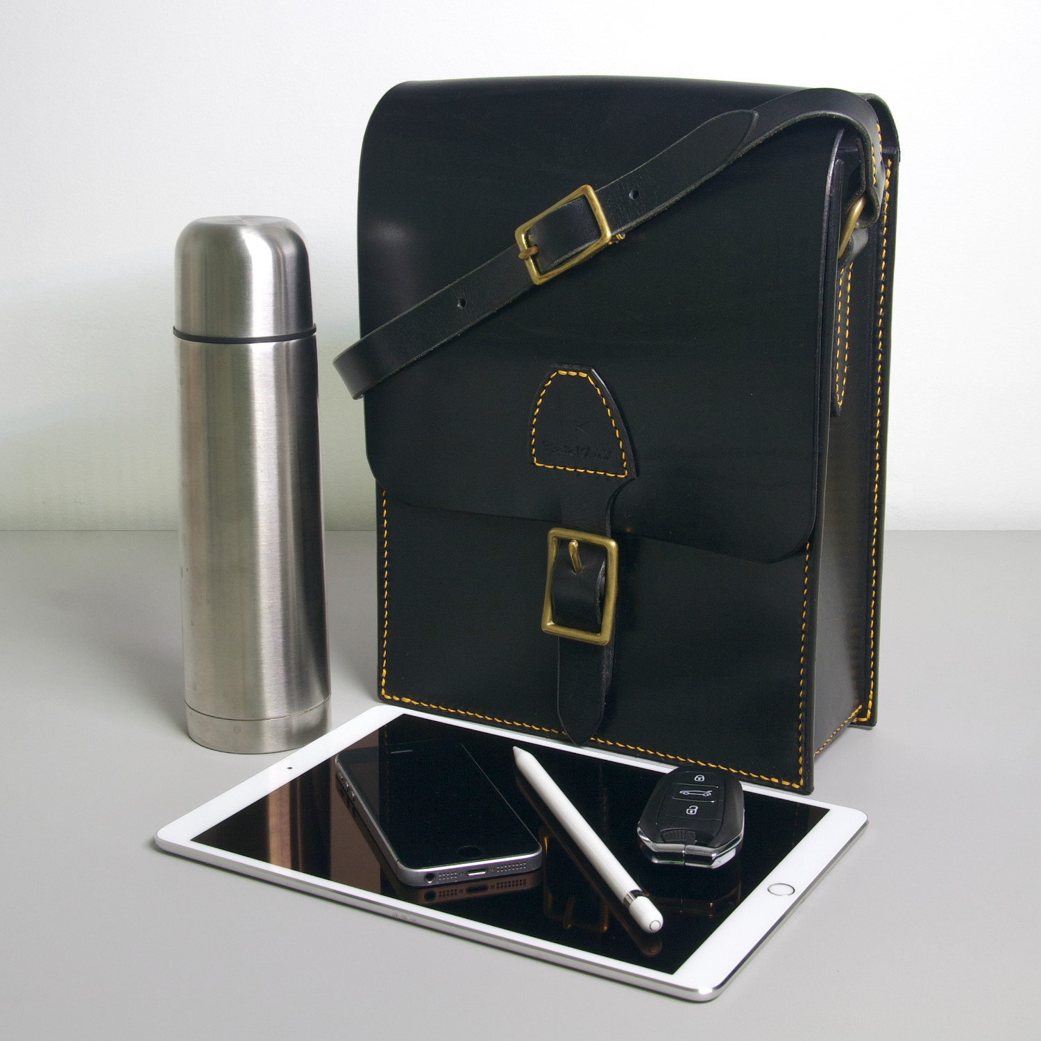 kožená messenger taška s mosadznou prackou a termoskou tabletom a kľúčmi