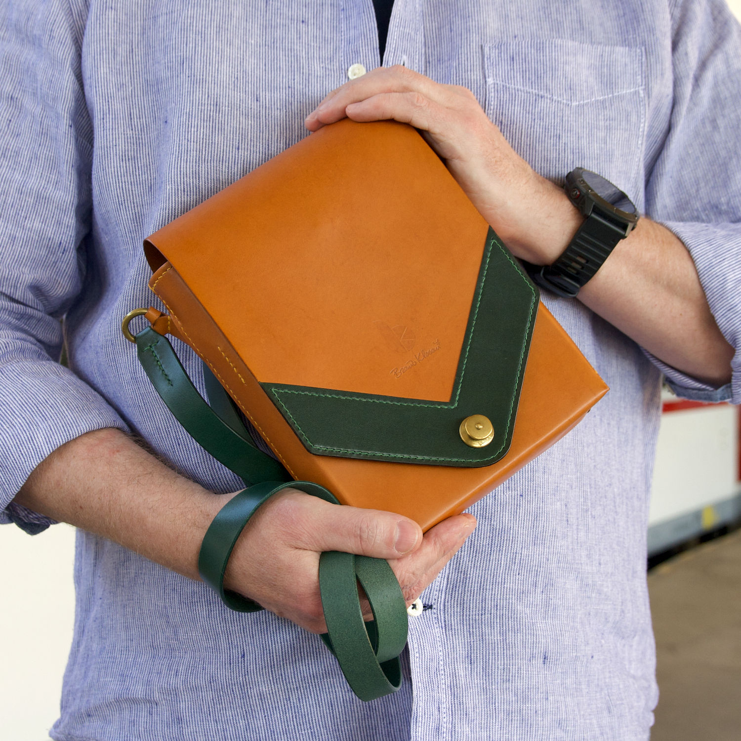 kožená messenger taška s loxx cvokom držaná v rukách